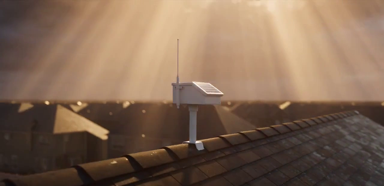 Concept scene: a small white solar relay with an antenna mounted on a rooftop at sunset.